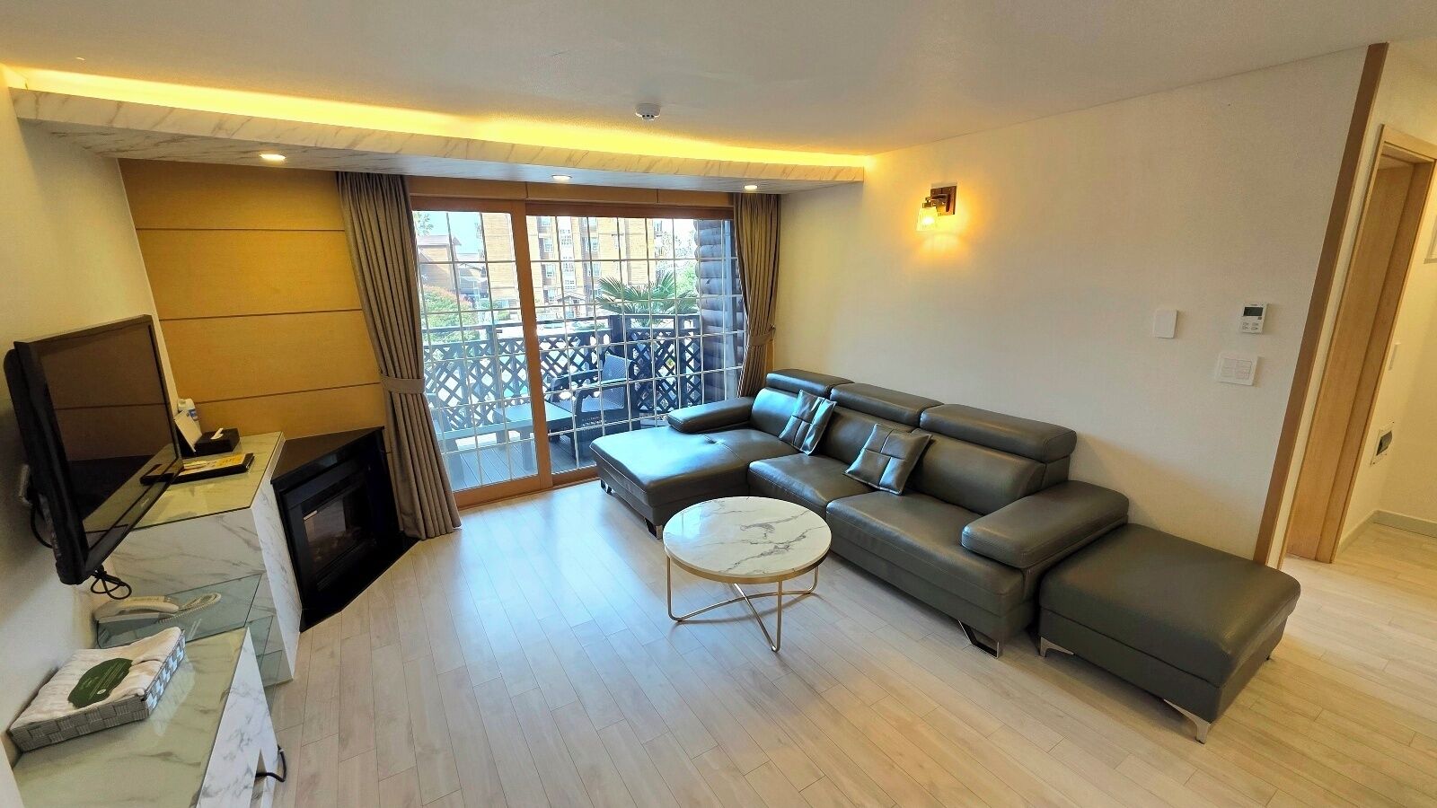 A modern living room with a large sectional sofa, a small round coffee table, and a television.