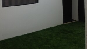 A room with a skylight, a large window, and a grassy area. - Lola's Lodge (Boracay Island)