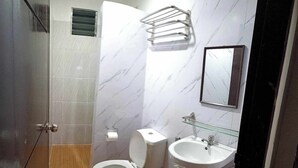 A bathroom with a toilet, sink, and shower area. - Lola's Lodge (Boracay Island)