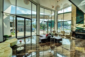 Relax in the spacious lobby with high ceilings and floor-to-ceiling windows offering views of the surrounding area.