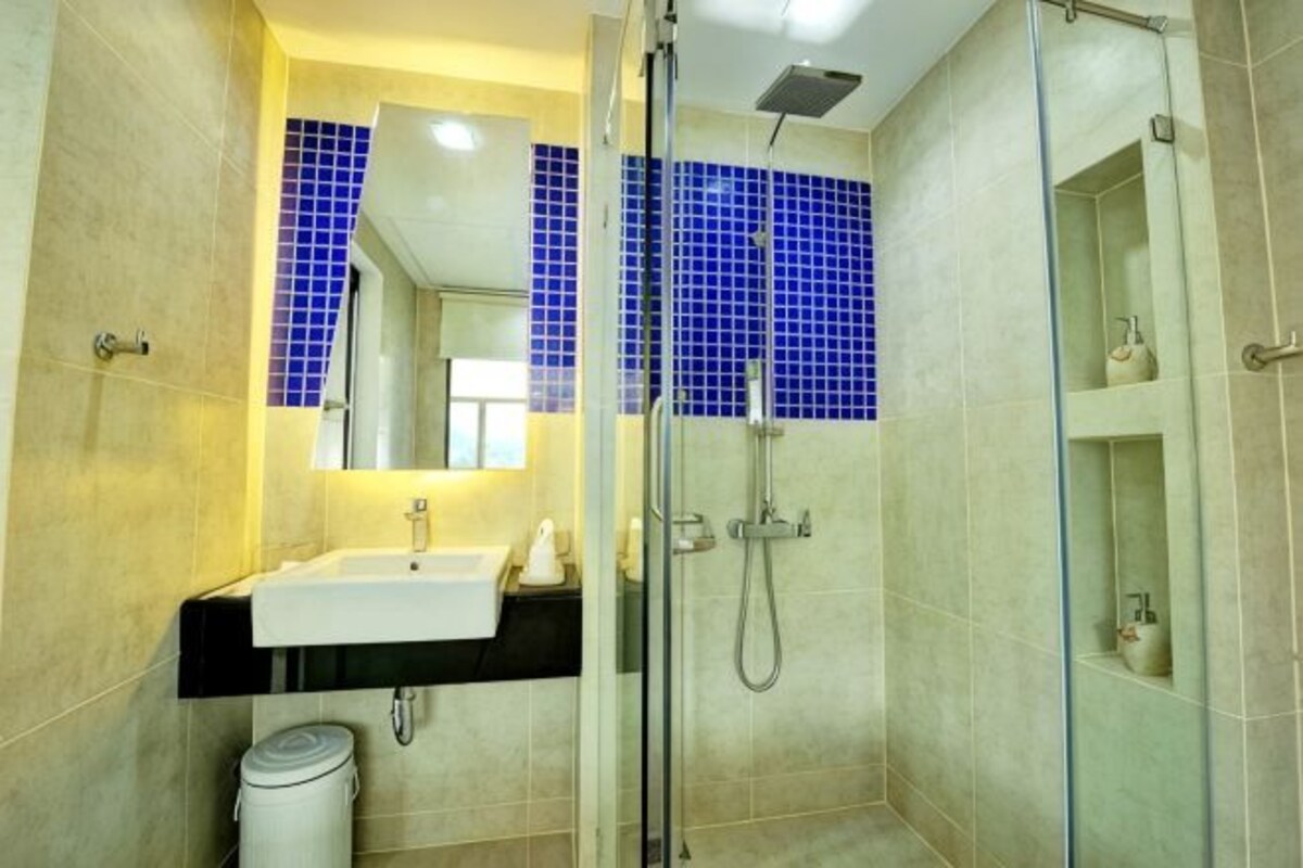 Un baño con cabina de ducha de vidrio, un lavabo y un espejo.