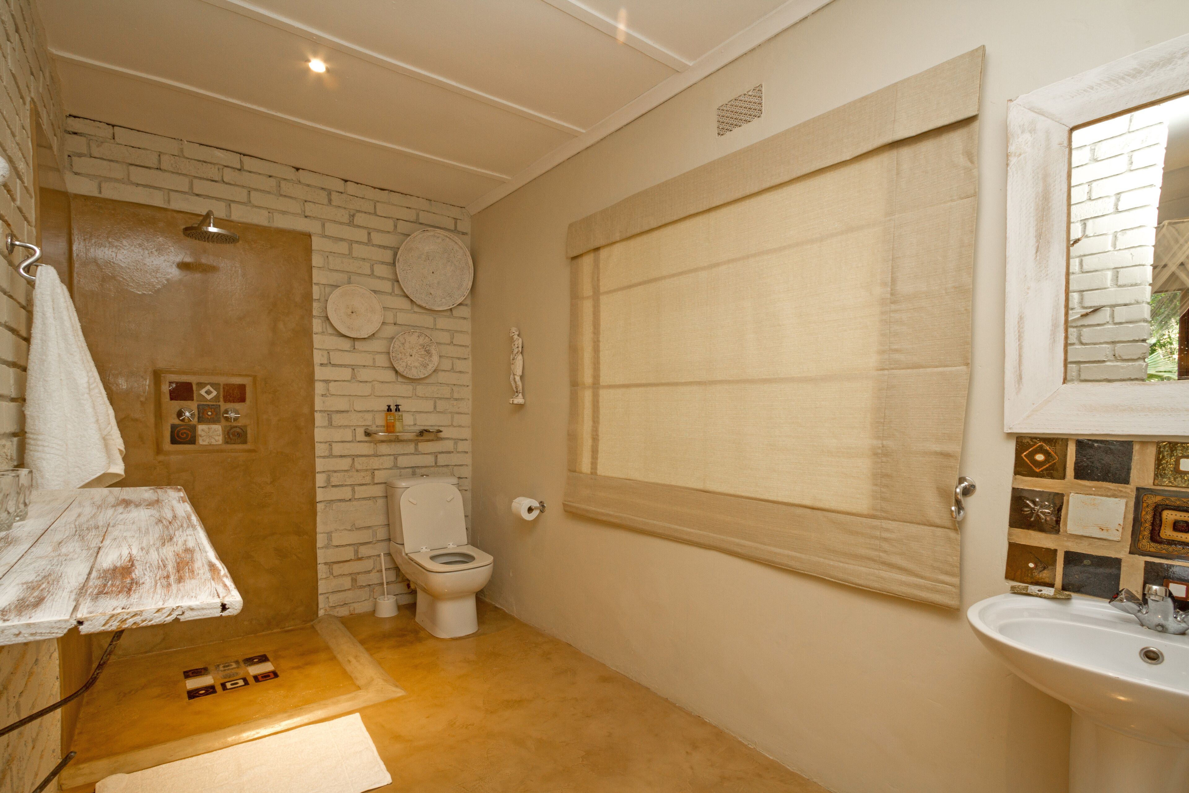 A bathroom with a shower, toilet, and sink.