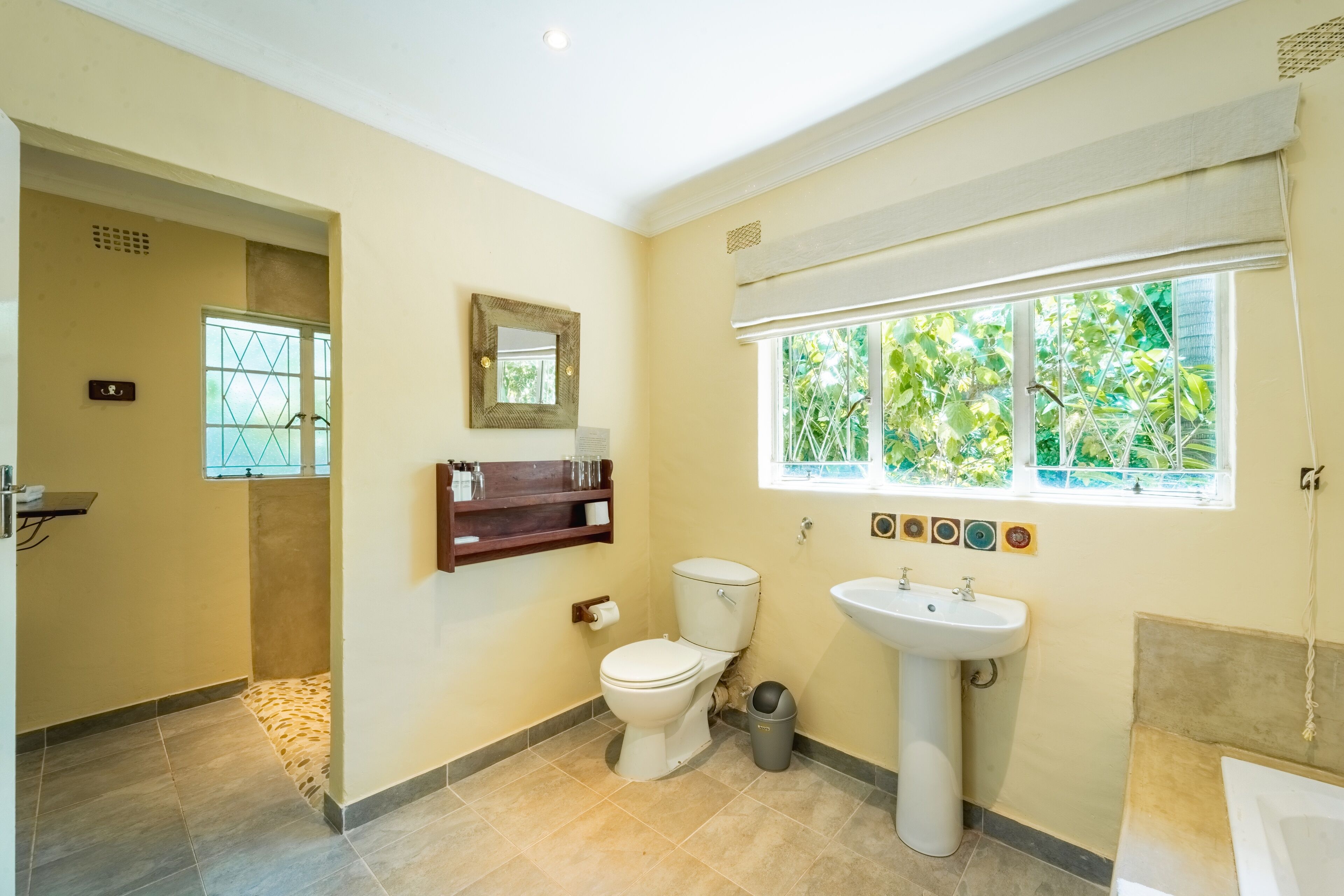 Une salle de bain avec des toilettes, un lavabo et une fenêtre.