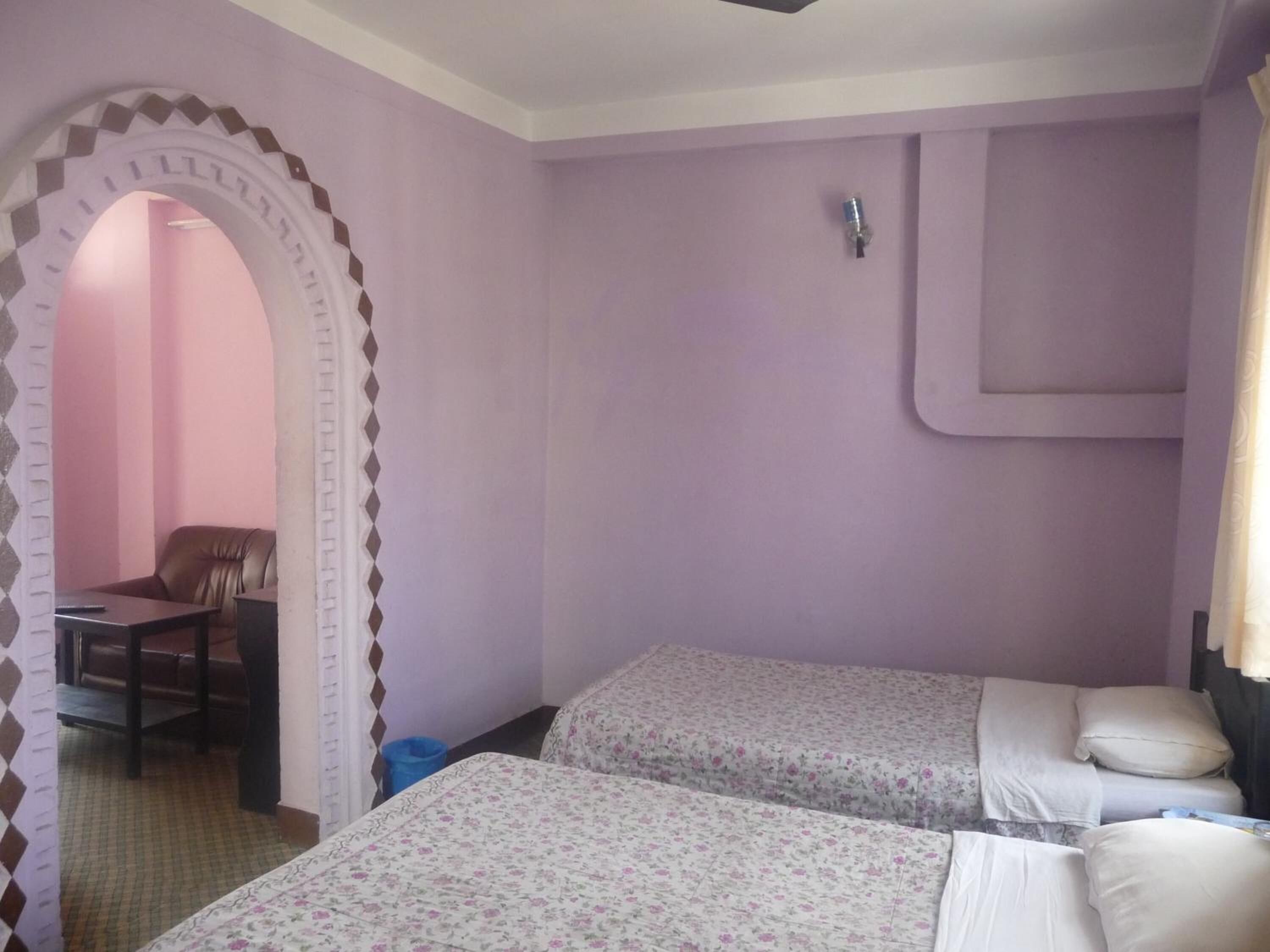Une chambre avec deux lits, un bureau et une chaise.