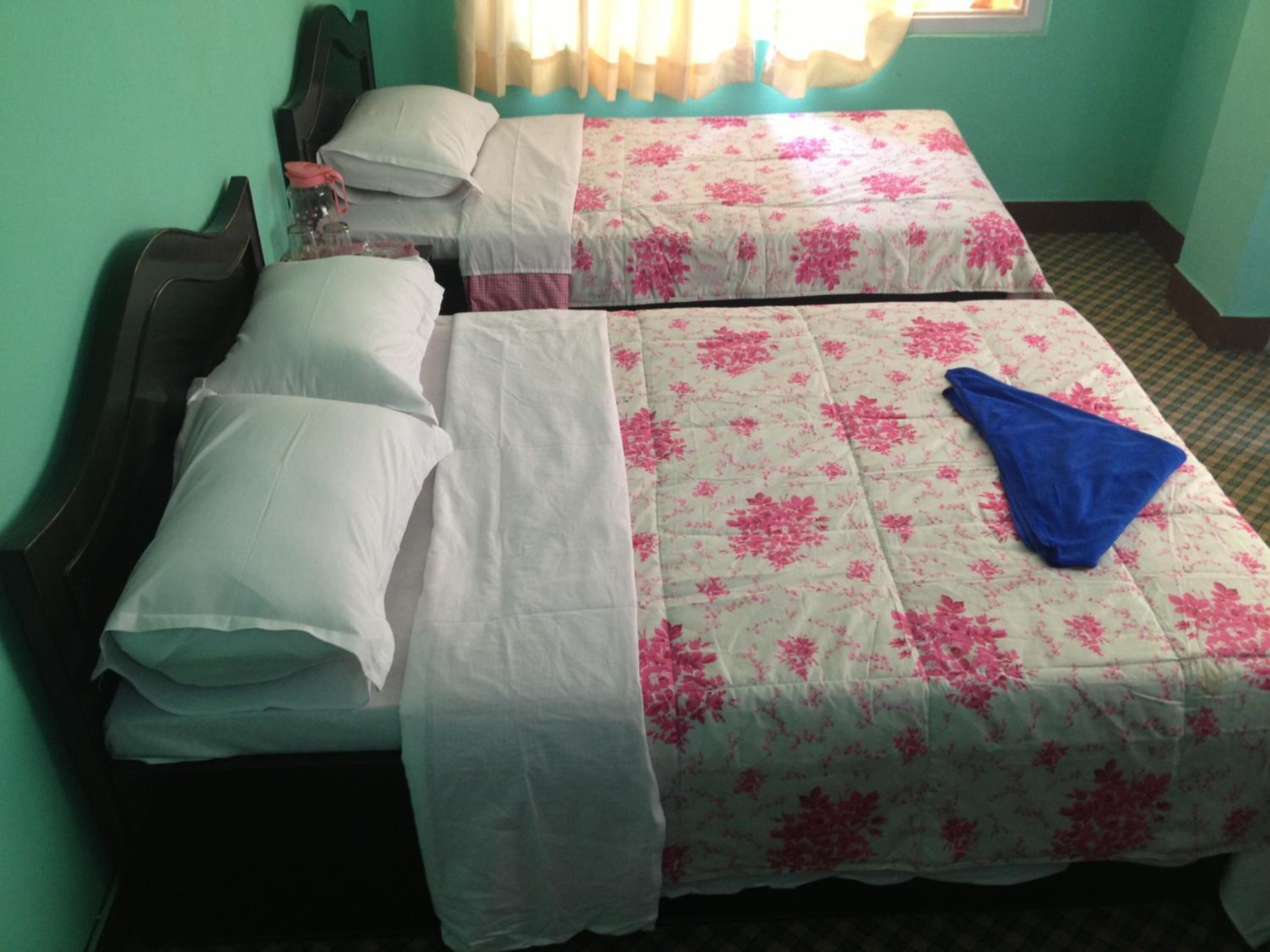 A twin room with two beds, each with a floral bedspread and white linens.