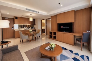 Une chambre d’hôtel avec un coin repas, une télévision et une kitchenette.