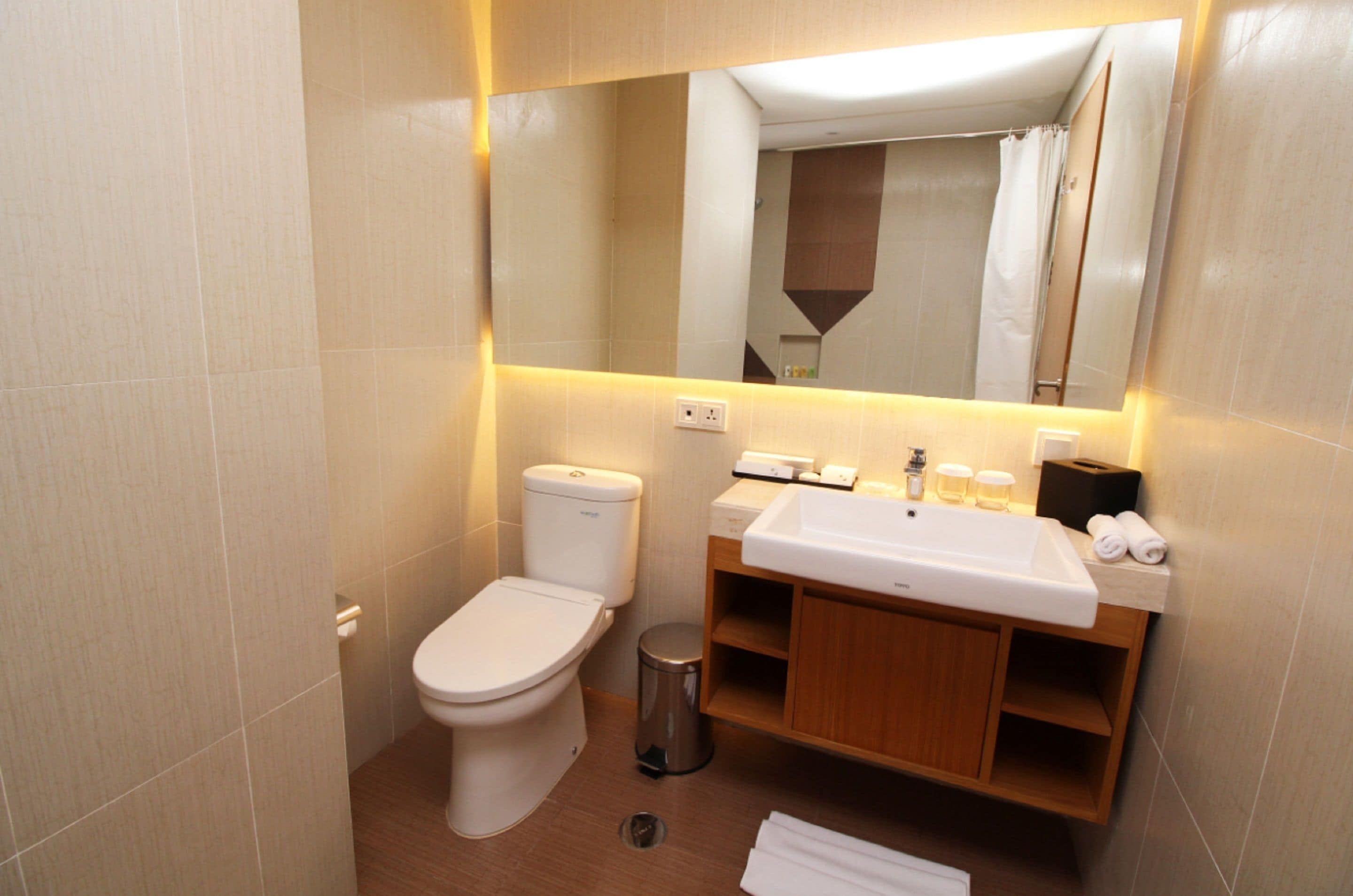 Une salle de bain moderne avec des toilettes, un lavabo et un miroir.