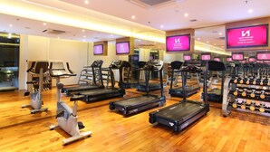 Un gimnasio con cintas de correr, elípticas y máquinas de pesas.