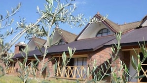A row of brick houses with sloped roofs and a wooden fence in the foreground. - Lalibela Lodge (Lalibela)