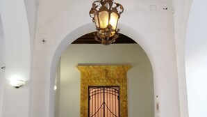 A grand entrance with a wrought iron gate, a decorative archway, and a hanging light fixture. - B&B Palazzo Benso (Palermo)