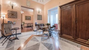 A spacious lobby with a large wooden cabinet, a chandelier, and a patterned floor. - B&B Palazzo Benso (Palermo)