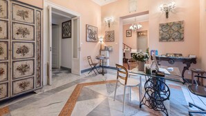 A dining area with a glass table, chairs, and a chandelier. - B&B Palazzo Benso (Palermo)