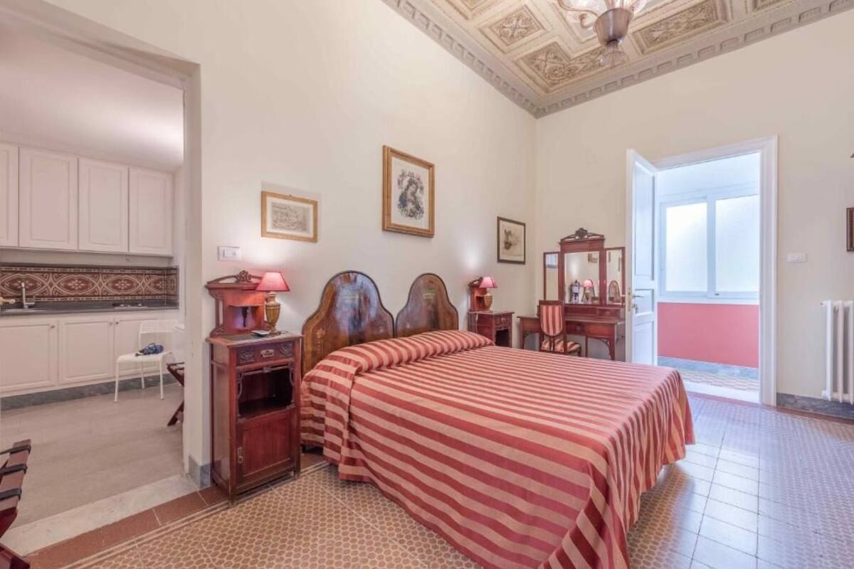 A bedroom with a bed, bedside tables, a dresser, a chair, and a window.