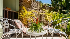 A patio area with two metal chairs, a small round table, and a potted plant. - Maison Soleil (Mahé Island)