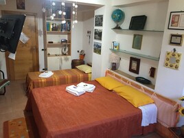 Una habitación con dos camas, una estantería, un globo terráqueo y varias fotografías enmarcadas.