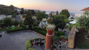 Un patio con una jardinera grande, un área de juegos y vistas al mar.