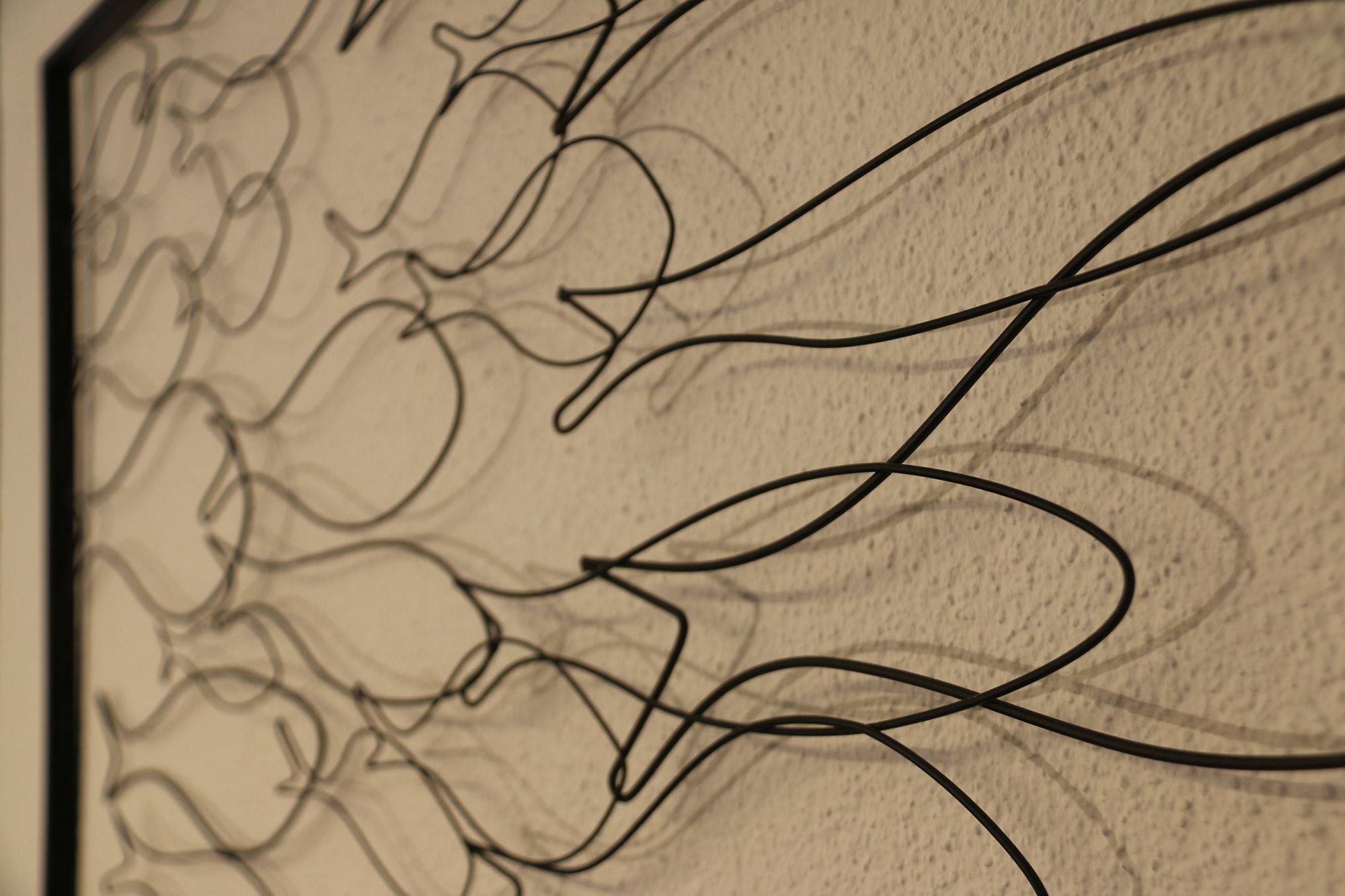 A close-up of a wall with abstract, intertwined lines.