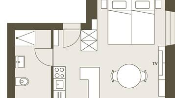 Plano de un cuarto de hotel que incluye televisión, mesa de comedor, zona de cocina y baño.