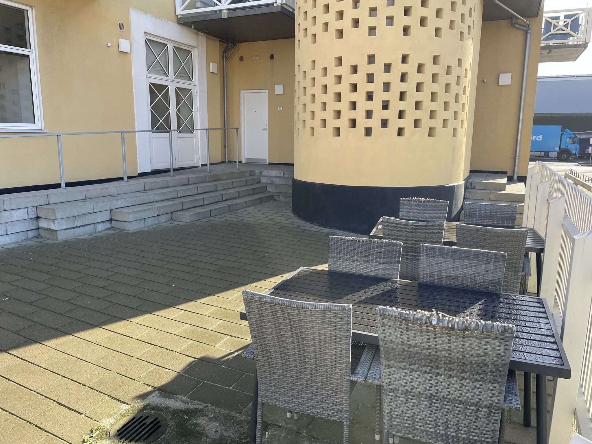 An outdoor patio with wicker furniture and a concrete floor.