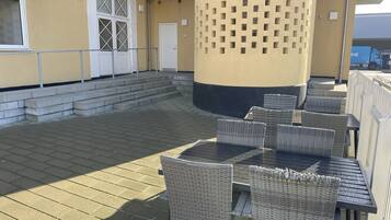 An outdoor patio with wicker furniture and a concrete floor.