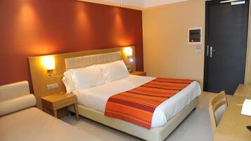Ein Hotelzimmer mit Bett, Nachttischen, Schreibtisch und Stuhl.