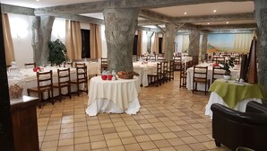 A restaurant with multiple round tables, wooden chairs, and a tiled floor. - Hotel Ristorante La Campagnola (Cassino)