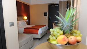 A hotel room with a bed, a bedside table with a fruit bowl, and a small seating area. - Hotel Ristorante La Campagnola (Cassino)