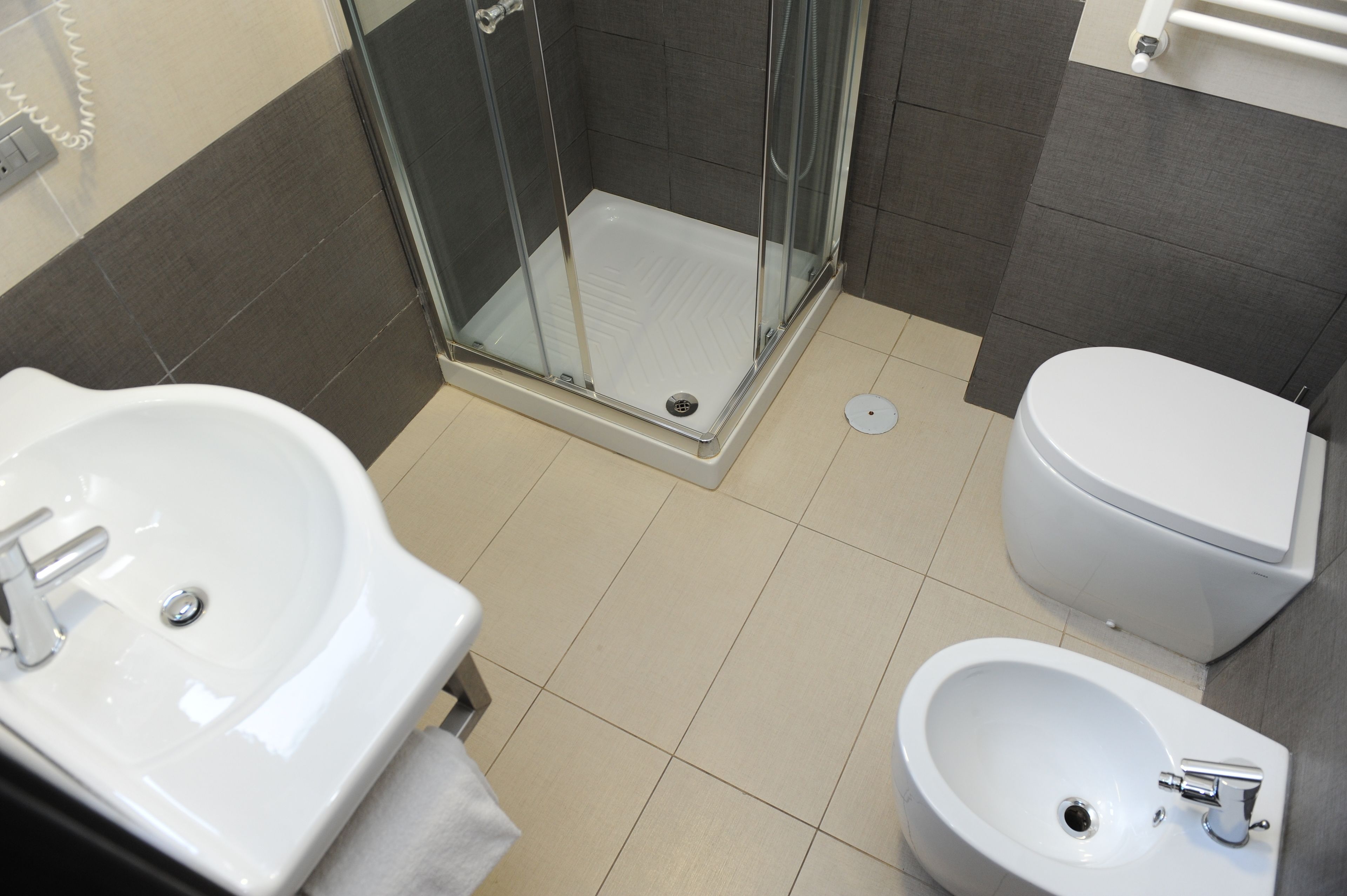 Un baño con ducha, inodoro, bidé y lavamanos.