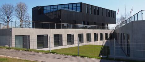 Un edificio moderno con techo plano, ventanas grandes y fachada de hormigón.
