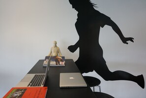 Un escritorio con una computadora portátil, un libro y una estatua.