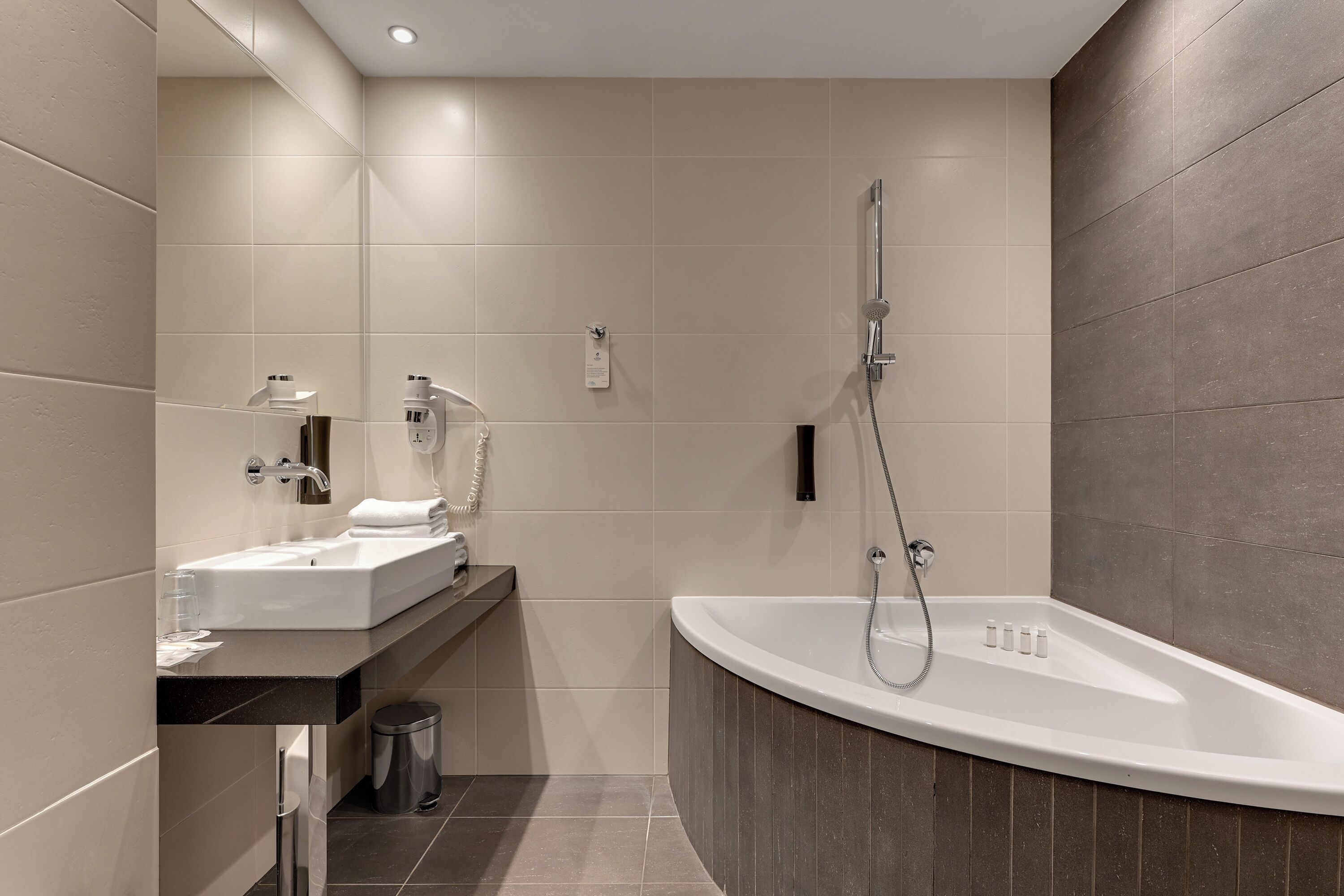 A modern bathroom with a freestanding bathtub, a vanity with a sink, and a mirror.