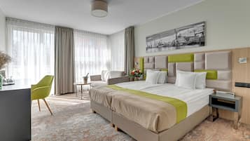 Habitación de hotel con una cama grande, un escritorio, una silla y un cuadro en la pared.