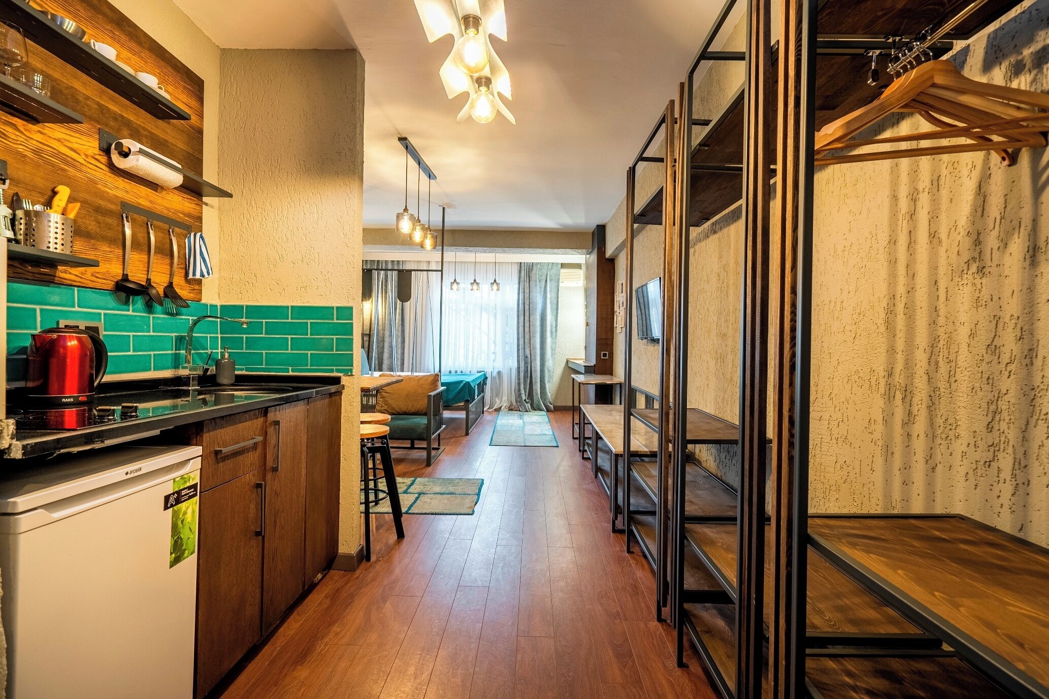 A compact kitchen with wooden cabinets, a coffee machine, and a dining area with a table and chairs.