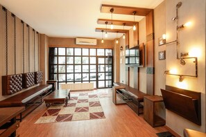 Un intérieur moderne avec une grande fenêtre, des bancs en bois, une table centrale et un éclairage fixé au mur.