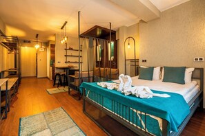 A hotel room with a bed, a desk, a chair, and a mirror.