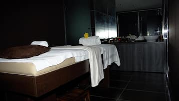 A modern hotel room with a large bed, a small bedside table, a large mirror, and a view of a bathroom with a bathtub.