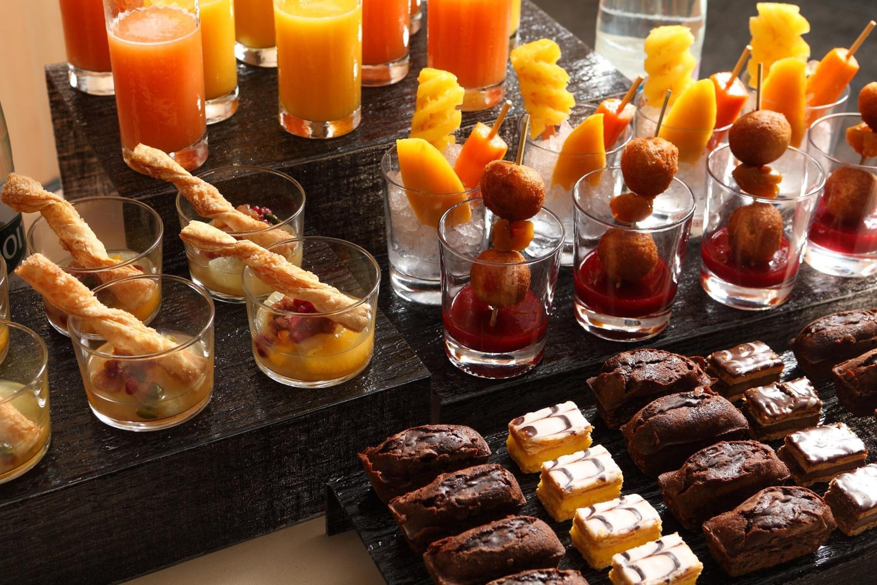 A variety of desserts and beverages on a buffet table.