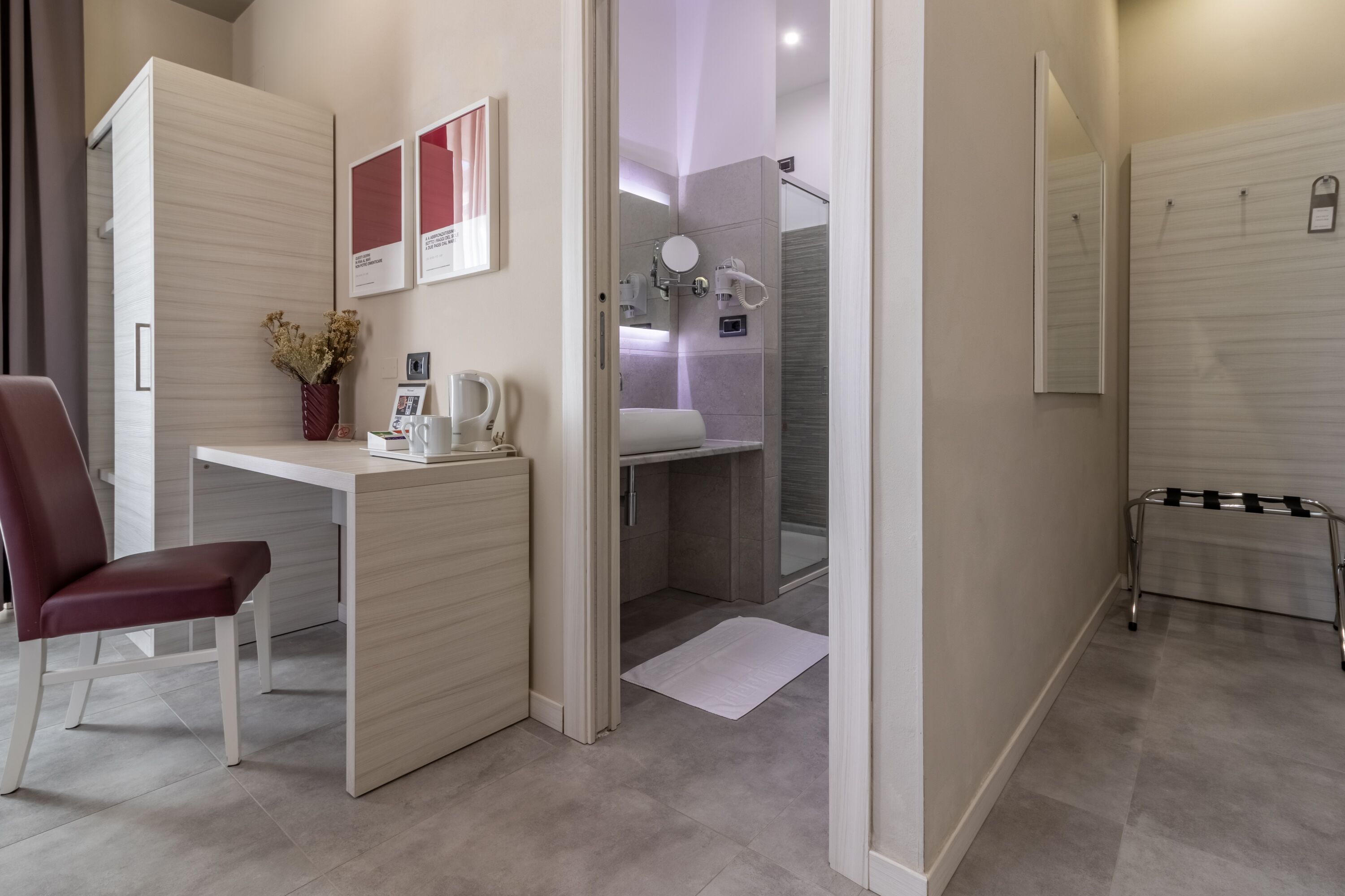 Une chambre d’hôtel moderne équipée d’un bureau, d’une chaise et d’un espace douche.