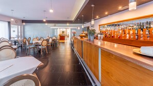 Ein modernes Restaurant mit Barbereich, Holzmöbeln und verschiedenen Sitzgelegenheiten.