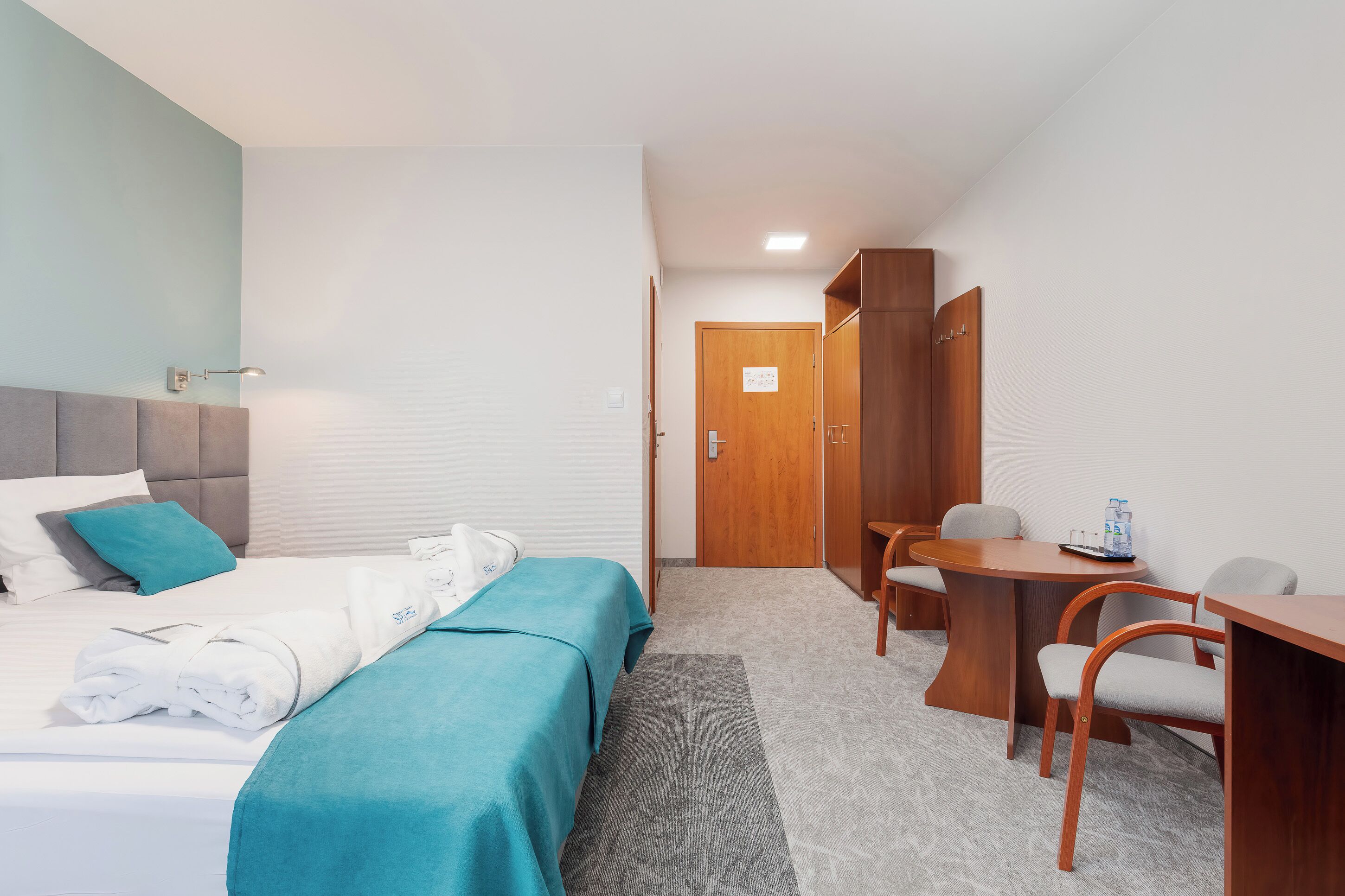 Ein Hotelzimmer mit Bett, Schreibtisch und Stuhl.