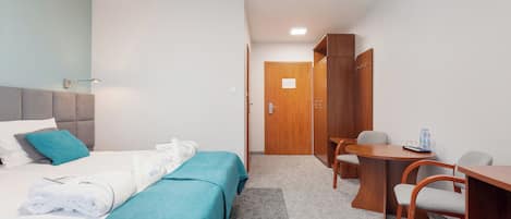 Ein Hotelzimmer mit Bett, Schreibtisch und Stuhl.
