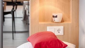 Ein modernes Zimmer mit einer Holzwand, einem roten Kissen, einem weißen Kissen und einer Wandleuchte.