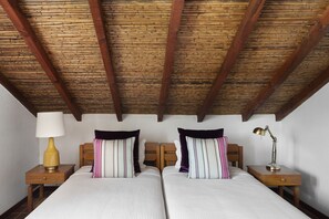 A double bed with striped pillows, a bedside lamp, and a wooden nightstand. - Quinta Do Moinho De Vento Duna Parque Resorts & Hotels (Odemira)