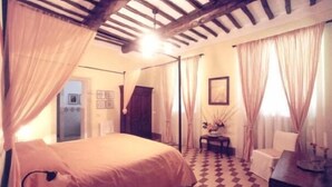 Un dormitorio con una cama, una silla, una mesa y un suelo a cuadros.