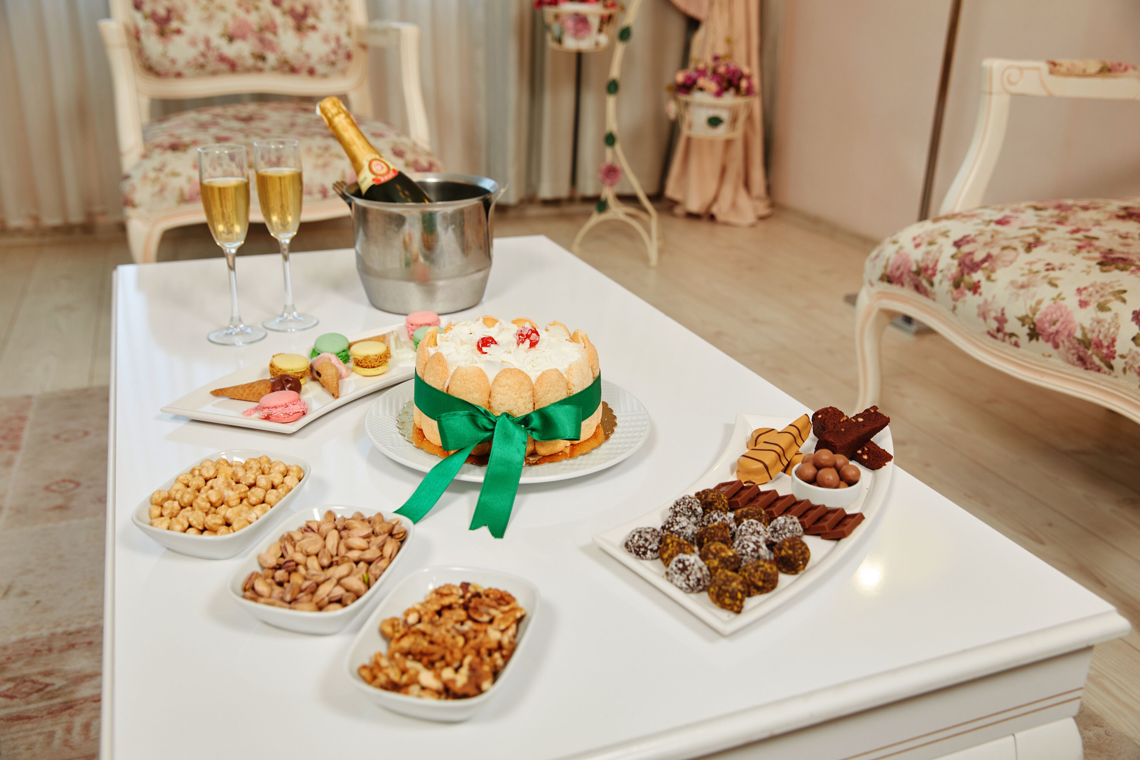 Une table avec un g âteau, du champagne et divers desserts.