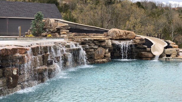 Ein Pool mit Wasserfall und Steinelement.