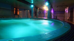 Ein großer, innenliegender Schwimmteich mit kreisförmiger Form und Fliesenboden.