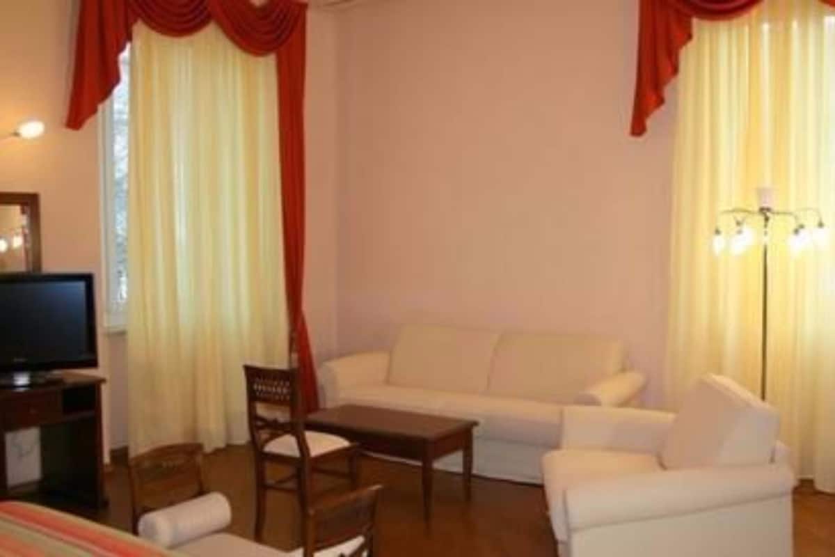 Una sala de estar con sofá, mesa de centro y televisor.