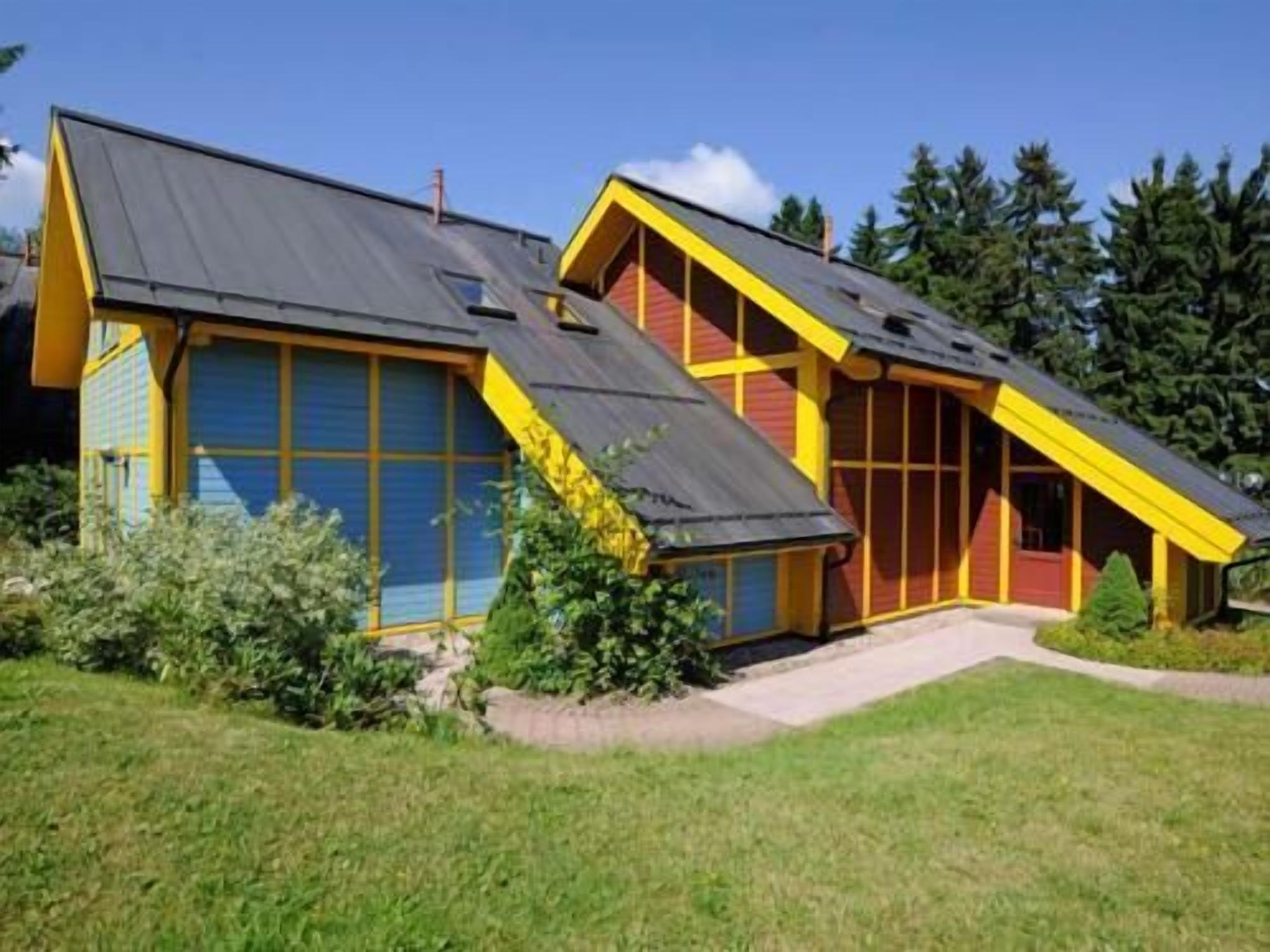Ein modernes Haus mit Satteldach, großen Fenstern und einem gepflegten Rasen.