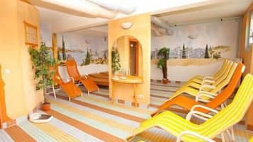 A room with striped floor tiles, a small table with a plant, and several lounge chairs.